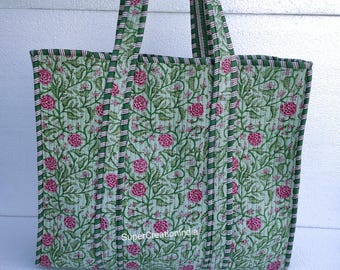 May include: A quilted tote bag with a floral pattern. The bag features a light green background with pink flowers and green leaves. The handles and edges are trimmed with green and pink stripes. The text "SuperCreationIndia" is visible on the bag.