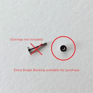 May include: A single silver earring backing. The backing is a small, round disc with a screw-on post. The text "(Earrings not included)" is written in red above the backing. The text "Extra Single Backing available for purchase" is written in red below the backing.