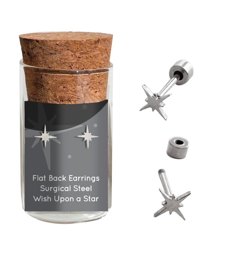 May include: A pair of silver star-shaped earrings in a glass jar with a cork lid. The jar has a black label that reads "Flat Back Earrings Surgical Steel Wish Upon a Star".