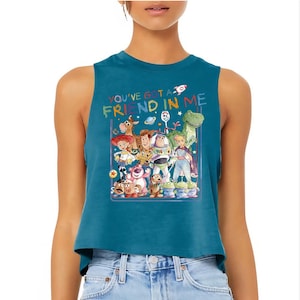 Puede incluir: Top corto sin mangas de color turquesa con un gr&aacute;fico colorido de personajes de Toy Story. El texto "YOU'VE GOT A FRIEND IN ME" est&aacute; impreso encima del gr&aacute;fico. La parte superior est&aacute; hecha de un material suave.