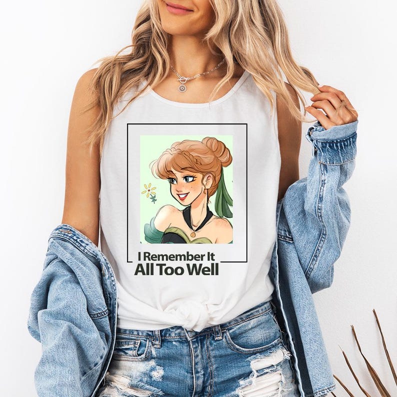 Puede incluir: Camiseta blanca de tirantes con un gr&aacute;fico de una mujer de dibujos animados con cabello casta&ntilde;o y un vestido verde. El texto "I Remember It All Too Well" est&aacute; impreso debajo del gr&aacute;fico.