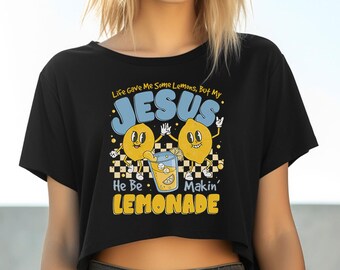 May include: Black crop top with a graphic featuring two cartoon lemons, a glass of lemonade, and the text "Life gave me some lemons, but my JESUS He Be Makin' LEMONADE."