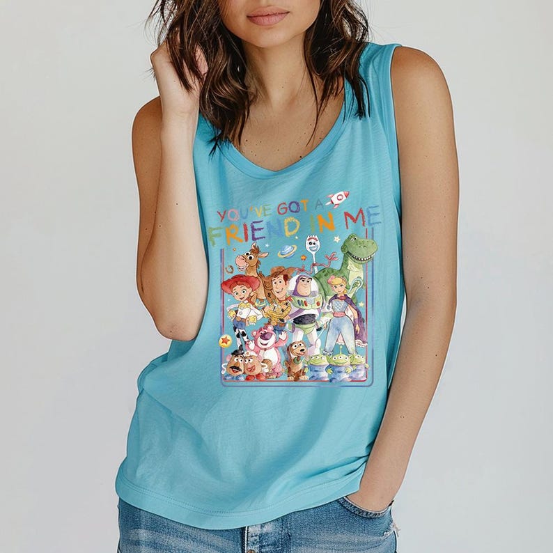 Pu&ograve; includere: Canotta azzurra con una grafica colorata dei personaggi del film "Toy Story". La grafica include Woody, Buzz Lightyear e altri personaggi, con la scritta "YOU'VE GOT A FRIEND IN ME."