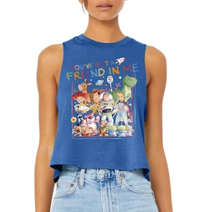 Puede incluir: Camiseta sin mangas azul con un gr&aacute;fico colorido de personajes de "Toy Story". El texto "YOU'VE GOT A FRIEND IN ME" se muestra encima de los personajes. El dise&ntilde;o incluye a Woody, Buzz Lightyear y otros personajes.