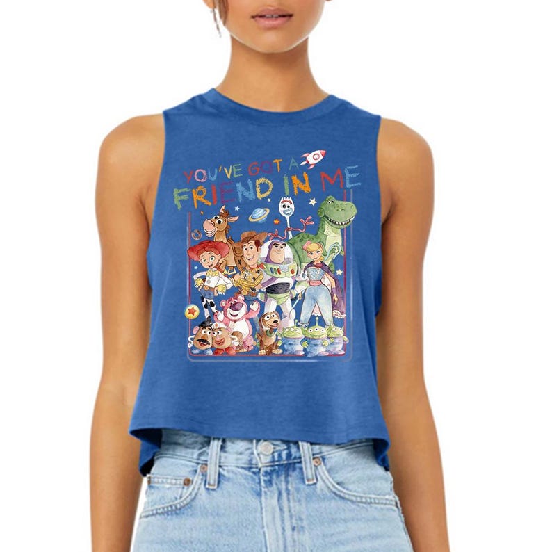Puede incluir: Camiseta sin mangas azul con un gr&aacute;fico colorido de personajes de "Toy Story". El texto "YOU'VE GOT A FRIEND IN ME" se muestra encima de los personajes. El dise&ntilde;o incluye a Woody, Buzz Lightyear y otros personajes.