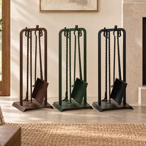 Può includere: Tre set di attrezzi per camino allineati, ciascuno dotato di un supporto metallico rettangolare, una paletta, un attizzatoio e una spazzola. I set sono rifiniti in marrone, verde scuro e nero, con manici in metallo intrecciato.