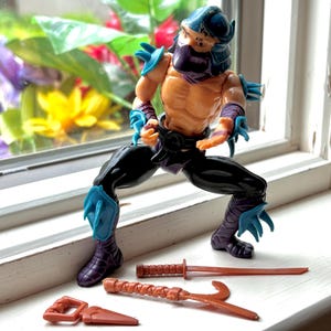 1988 Shredder Hard Head Teenage Mutant Ninja Turtles action figure with belt and some accessories