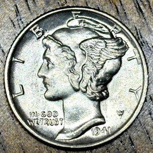 May include: A silver Mercury dime from 1941. The obverse features a profile of a woman wearing a winged Phrygian cap, with the inscriptions "LIBERTY" and "IN GOD WE TRUST". The year "1941" is visible.