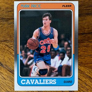 May include: A Fleer basketball card featuring Mark Price. The card shows Mark Price in a blue and red Cavaliers uniform, holding a basketball. The card has an orange and blue border with the text "MARK PRICE" and "CAVALIERS".