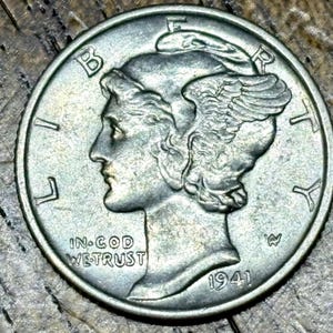 May include: A close-up of a silver 1941 Mercury dime. The coin features a profile of a woman with a winged cap and the words "IN GOD WE TRUST". The year "1941" is visible.