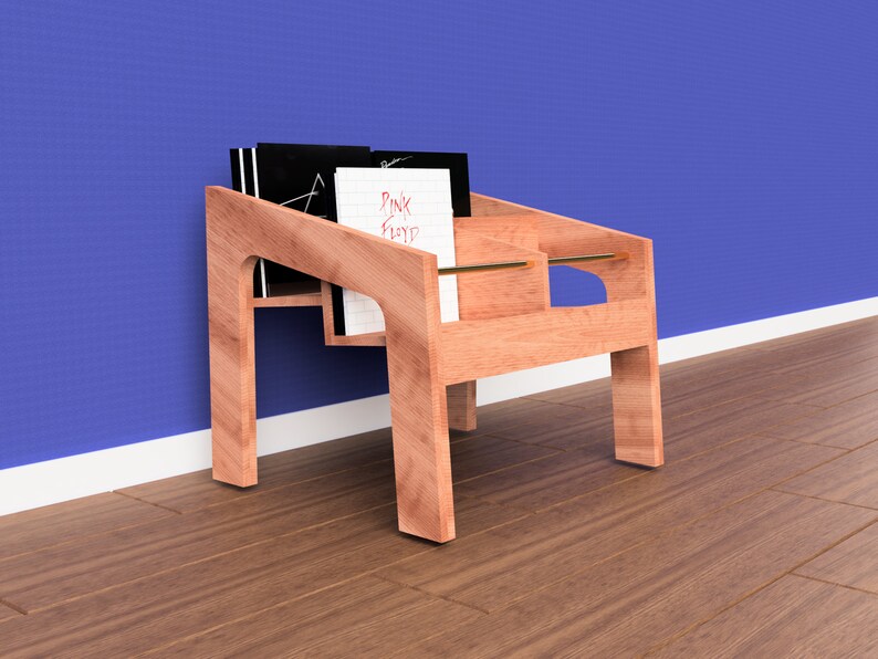 K&ouml;nnte beinhalten: Ein Holz-Plattenst&auml;nder mit zwei Regalen, auf denen ein Stapel Schallplatten liegt. Der St&auml;nder ist aus hellem braunem Holz gefertigt und hat ein schlichtes, modernes Design. Der Plattenst&auml;nder steht auf einem Holzboden vor einer blauen Wand.