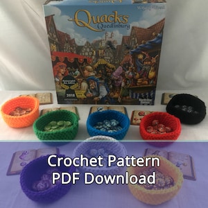 May include: Crochet pattern PDF download for making colorful dice storage containers. The image shows eight crocheted containers, each filled with dice, and a board game box in the background.