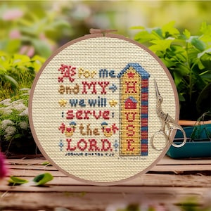 May include: A beige embroidery hoop with a cross-stitch design featuring a house and the text "As for me and my house we will serve the LORD! Joshua 24:15 KJV".
