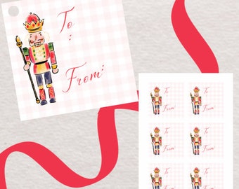 Peut inclure: Étiquettes cadeaux avec une illustration à l'aquarelle d'un soldat casse-noisette sur un fond à carreaux rose et blanc. Les étiquettes portent les mots "To :" et "From :" en écriture rouge. Un ruban rouge est drapé sur l'image.
