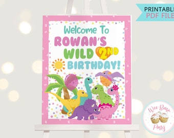 May include: A pink printable sign with the text "Welcome to Rowan's Wild 2nd Birthday!" and a cartoon illustration of dinosaurs and a palm tree. The sign is decorated with colorful confetti.