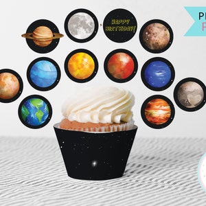 Puede incluir: Envoltorios de magdalenas imprimibles con temática espacial. Los envoltorios son negros con estrellas blancas y presentan imágenes de planetas, incluyendo Saturno, Júpiter, Marte y la Tierra. El texto "¡Feliz cumpleaños!" está incluido en uno de los envoltorios.