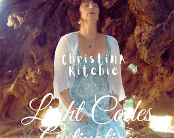 Puede incluir: Una mujer se sienta debajo de un gran árbol, con un cárdigan de ganchillo blanco y un vestido estampado azul. El texto "Christina Ritchie Light Codes Activation" está escrito en blanco en la imagen.