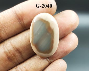 May include: An oval-shaped gemstone with a polished surface. The stone features a central gray-blue area surrounded by a band of brown and a creamy white outer edge. The text "G-2040" is printed at the top.
