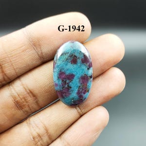 May include: Oval cabochon gemstone with a blue and purple color pattern. The stone is set in a silver ring. G-1942