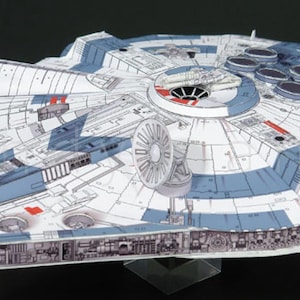 Puede incluir: Un modelo de papel detallado de una nave espacial circular con un esquema de colores blanco y azul, que presenta paneles intrincados, una cabina lateral, una antena de radar circular y múltiples salidas de escape de motor en la parte trasera.