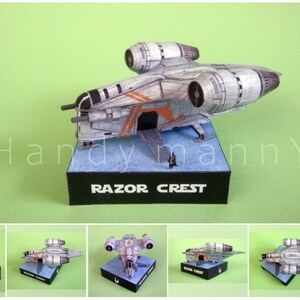 May include: A detailed model of the Razor Crest starship, a spacecraft from a popular science fiction series. The model is primarily gray with orange accents and is displayed on a black base with the text "RAZOR CREST".