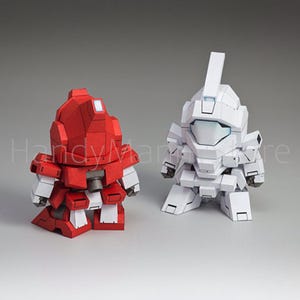 May include: Two stylized robot figures, one red and one white, stand side-by-side. The red robot has white accents, while the white robot has a blue visor. Both figures have a blocky, geometric design, suggesting a toy or collectible item.