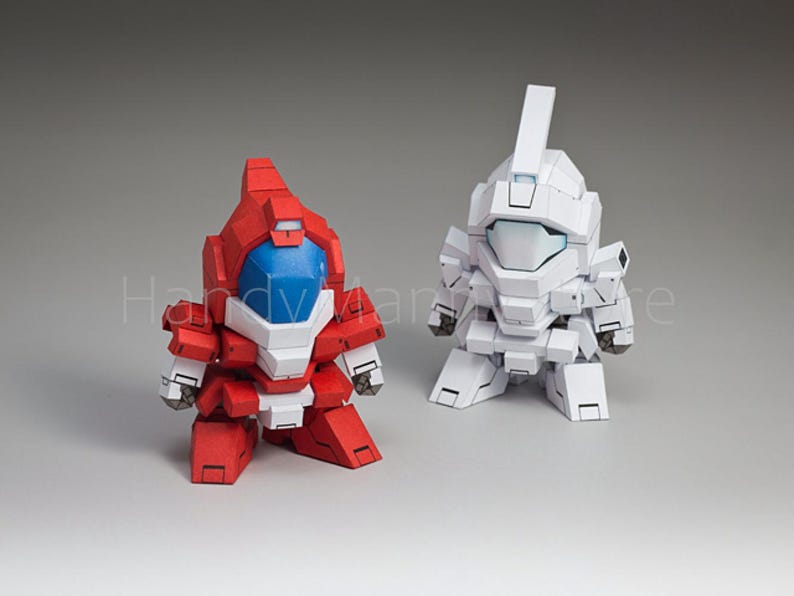 May include: Two robot figurines, one red and white, the other white. The red robot has a blue visor and white accents. The white robot has a rectangular head and a similar design. Both are stylized and have a blocky appearance.