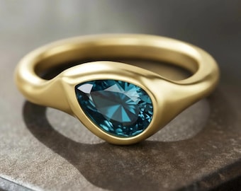 Anillo de topacio azul Pear London con engaste de bisel y baño de oro de 18k.