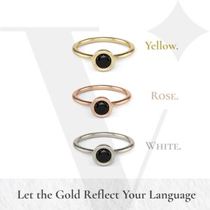 three rings with black stones, each with a different color: gold, rose, and white. The text above the rings reads "Yellow. Rose. White." and below the rings, it says "Let the Gold Reflect Your Language."