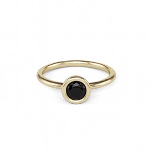 A gold ring with a black gemstone in the center.