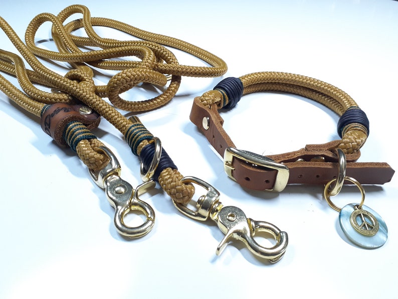 Puede incluir: Un juego de correa y collar para perro de cuerda marr&oacute;n con hebilla de cuero y un dije de signo de paz. La correa tiene dos clips dorados.