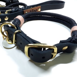May include: Black leather dog collar with a gold buckle and a matching rope leash with pink accents. The leash has a leather tag with the name "Alice" engraved on it.