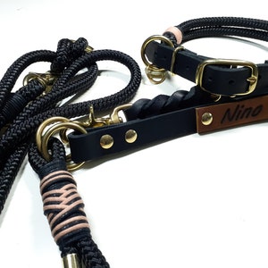 May include: Black leather dog collar and leash set with gold hardware. The collar has a brown leather tag with the name "Nino" engraved on it.