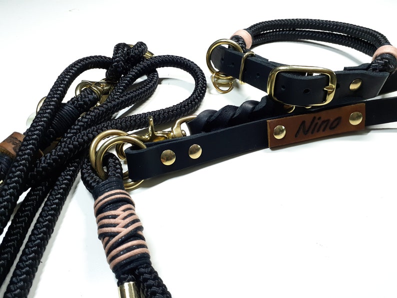 May include: Black leather dog collar and leash set with gold hardware. The collar has a brown leather tag with the name "Nino" engraved on it.