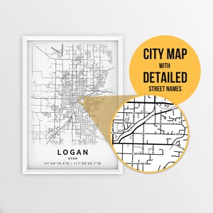 May include: A black and white city map of Logan, Utah with detailed street names. The map is framed in a white frame and is hanging on a white wall. The map includes the coordinates 41°44'16.4"N 111°50'20.7"W.