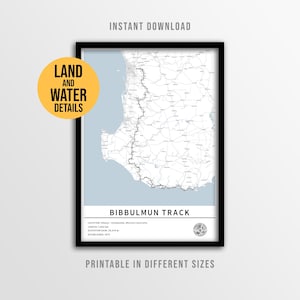 May include: A framed map print of the Bibbulmun Track in Western Australia, featuring a light blue ocean, white landmass, and a black trail line. Text includes the track name, location, 1,000 km length, 28,879 m elevation gain, and 1972 establishment.