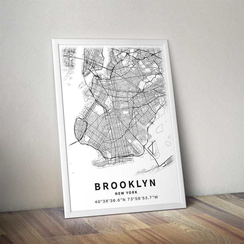 May include: A framed wall art print featuring a detailed black and white street map of Brooklyn, New York. The print includes the text BROOKLYN, NEW YORK, and the coordinates 40&deg;38'36.6"N 73&deg;56'53.7"W printed in a clean, sans-serif font below the map.
