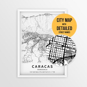 May include: A framed black and white map print of Caracas, Venezuela, featuring topographic lines and a circular inset showing detailed street names. The text reads CITY MAP WITH DETAILED STREET NAMES, CARACAS, VENEZUELA, and coordinates.