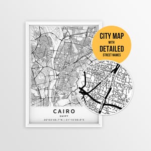 Może przedstawiać: Oprawiona czarno-biała mapa Kairu w Egipcie ze szczegółowymi nazwami ulic. Okrągła wstawka przedstawia fragment mapy. Tekst "CITY MAP WITH DETAILED STREET NAMES" znajduje się na żółtym okręgu.