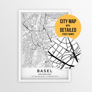 May include: A framed black and white city map of Basel, Switzerland, featuring a detailed street grid. A circular inset shows a zoomed-in view of street names including Austrasse and Holbeinstrasse. Text reads CITY MAP WITH DETAILED STREET NAMES.