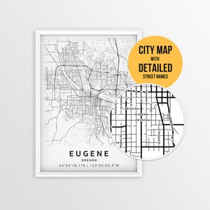 May include: A black and white city map print of Eugene, Oregon, with detailed street names. The map is framed in a white border and includes the city's coordinates. A circular inset highlights a section of the map.