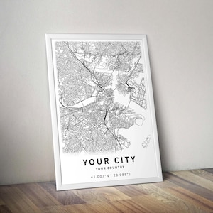 May include: A framed black and white map print. The map depicts a city's street layout with intricate details. The text "YOUR CITY, YOUR COUNTRY" is printed at the bottom, along with the coordinates 41.007&deg;N | 28.988&deg;E.