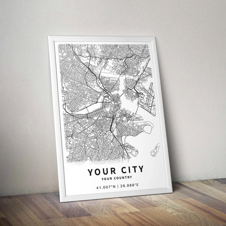 May include: A framed black and white map print. The map depicts a city's street layout with intricate details. The text "YOUR CITY, YOUR COUNTRY" is printed at the bottom, along with the coordinates 41.007&deg;N | 28.988&deg;E.