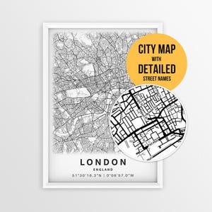 以下が含まれることがあります： ロンドン、イングランドの白黒の地図が額縁に入っており、詳細な道路網が描かれています。円形のインセットには、Regent StやPall Mallなどの通りの名前が拡大表示されています。テキスト：CITY MAP WITH DETAILED STREET NAMES、LONDON、ENGLAND。