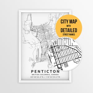 May include: A framed black and white map of Penticton, British Columbia, Canada, featuring street names and coordinates. A circular inset shows a magnified view of the street grid. A yellow circle contains the text CITY MAP WITH DETAILED STREET NAMES.