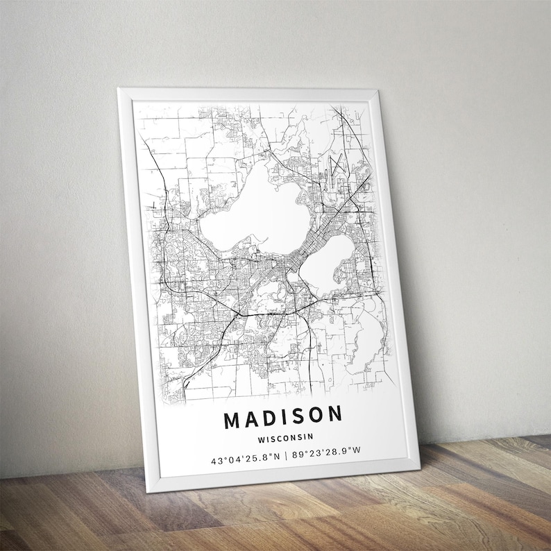May include: A framed vertical wall art print featuring a black and white street map of Madison, Wisconsin. The print includes the text MADISON, WISCONSIN, and the coordinates 43&deg;04'25.8"N | 89&deg;23'28.9"W printed in a clean, sans-serif font at the bottom.