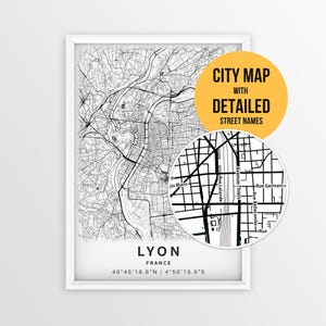 May include: A framed black and white map of Lyon, France, featuring detailed street layouts and names. The print includes the city name, country, and coordinates at the bottom. A circular inset highlights specific street labels like Rue Lalande.