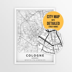 May include: A framed black and white city map of Cologne, Germany, featuring a circular inset showing detailed street names like Severinstraße and Ubierring. The print includes the text COLOGNE, GERMANY, and coordinates 50°57'31.1"N | 6°56'22.5"E.