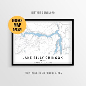 May include: A framed map print of Lake Billy Chinook in Oregon, featuring light blue water against a white background with gray topographical lines. The text reads LAKE BILLY CHINOOK, OREGON, 44.5900 N, 121.3743 W, with a yellow circle stating MODERN MAP DESIGN.