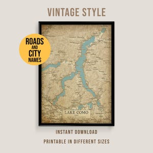 May include: A framed vintage-style map of Lake Como, Italy, with roads and city names. The map features a light blue lake and surrounding areas in beige tones. Text on the image includes "Lake Como" and "Instant Download, Printable in Different Sizes."